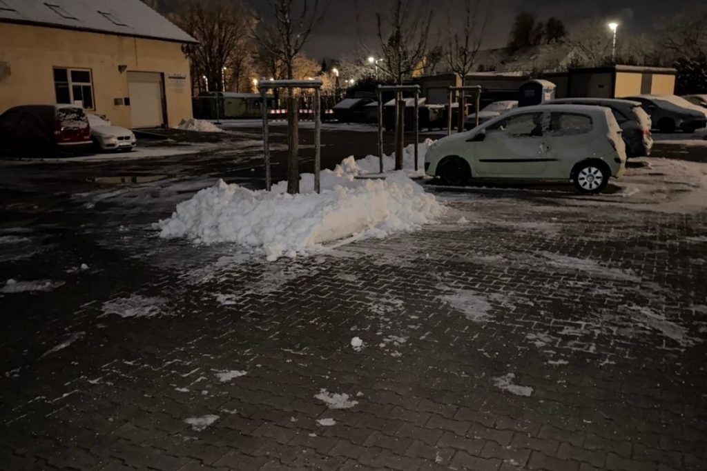 Winterdienst auf einem Parkplatz am Bodensee mit geräumten Fahr- und Gehflächen